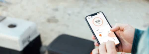 Mano sujetando un móvil con la aplicación de Jackery controlando la estación.