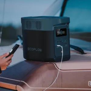 Estación de energía EcoFlow Delta 2 sobre una furgoneta camper cargando un smartphone en exteriores.