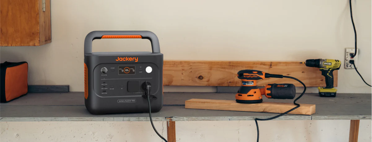 La estación de energía Jackery 1000 v2 alimentando una lijadora eléctrica profesional en un banco de trabajo de madera.
