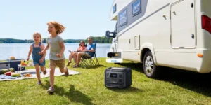 Familia disfrutando del camping con la Bluetti Elite 300 conectada a una caravana mediante su puerto de 12V y 30A.