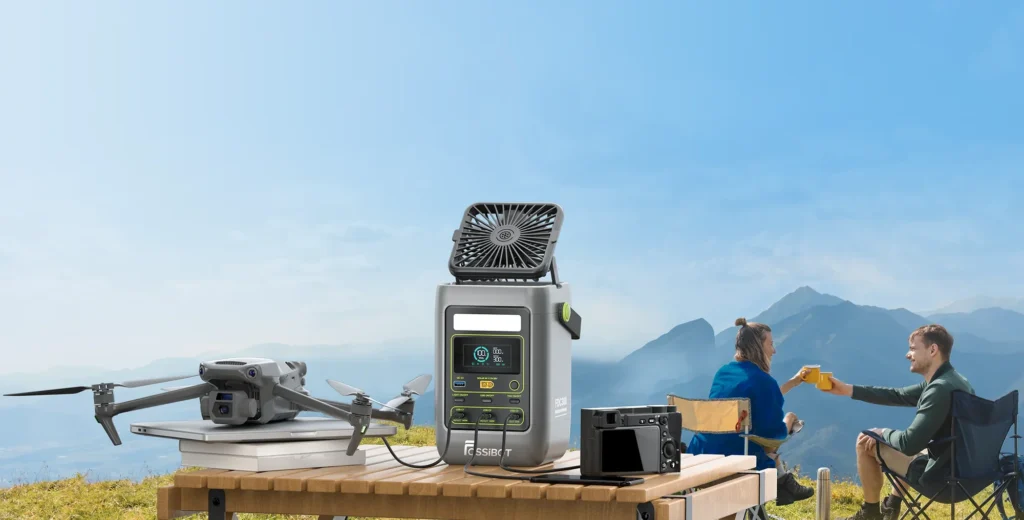 FOSSiBOT FDC300 alimentando un dron profesional, una cámara fotográfica y un portátil en la montaña.